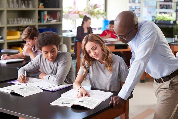 Teacher and students reviewing course materials