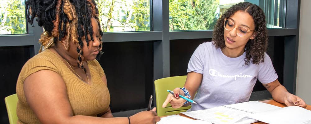 An FLCC student works her coursework with the help of a tutor.