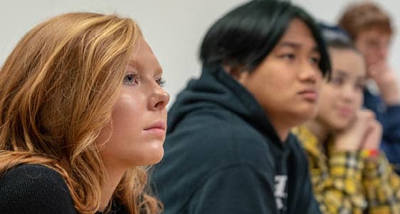 A row of students in an FLCC classroom listening to a college lecture.