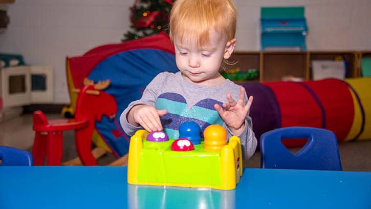 A toddler playing with shapes.