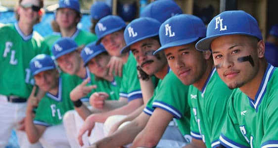 Members of the FLCC men's baseball team in the dugout during a game.